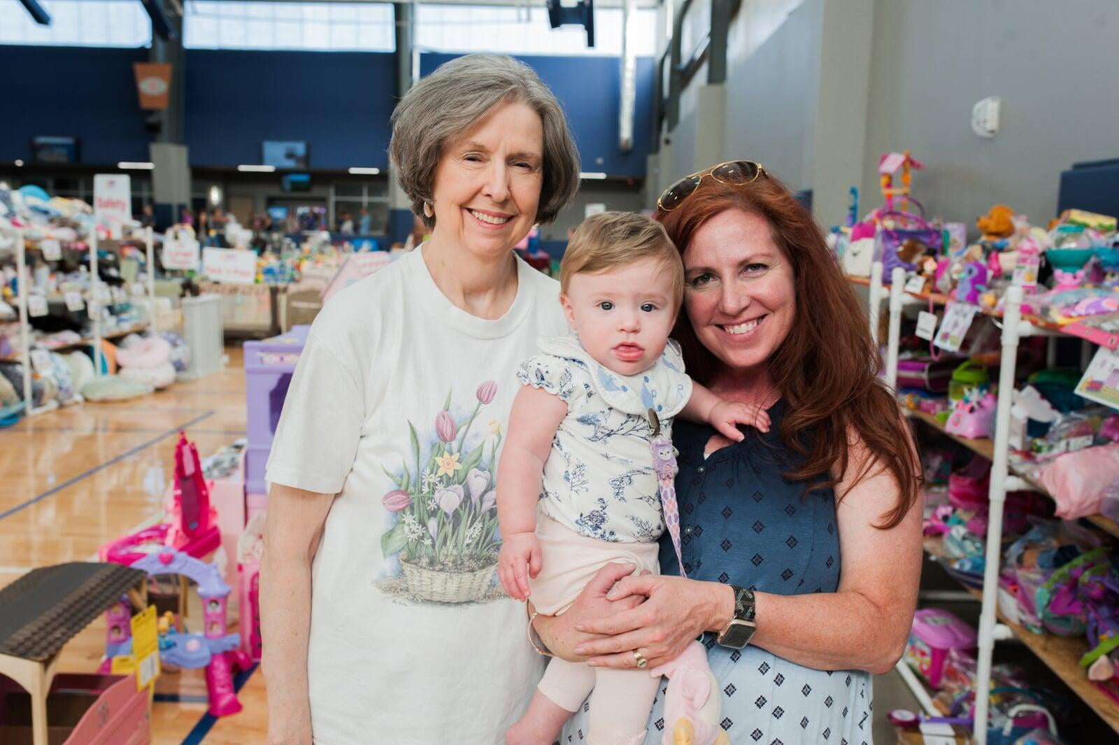 A mother and daughter stand side by side in their masks as they shop their local JBF sale.